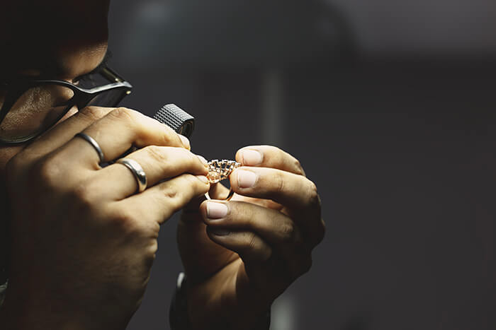 Artisan checking the clarity and color of diamond